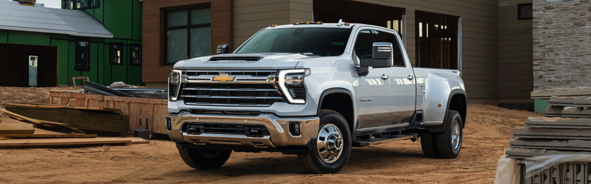 2025 Chevrolet Silverado 2500 HD white heavy-duty pickup truck at a construction site