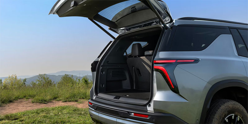 2026 Chevrolet Traverse silver SUV with rear trunk open, showcasing its spacious cargo area and practical boot space.